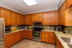 The large kitchen boasts quality stainless appliances and is stocked with dishes, glassware, and utensils.